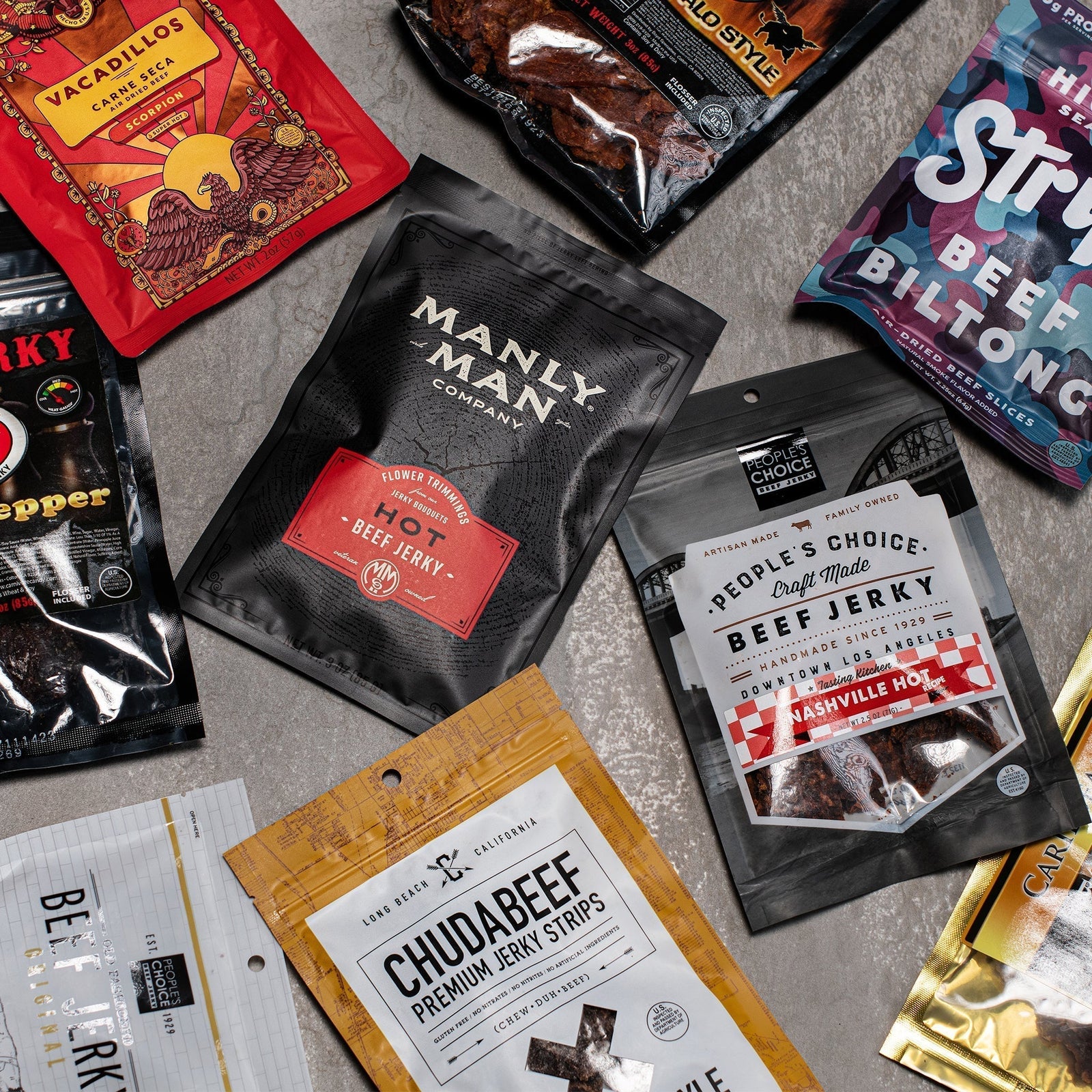 Flat lay of assorted Manly Man Co. beef jerky flavors and snacks, perfect for Father’s Day gifts.