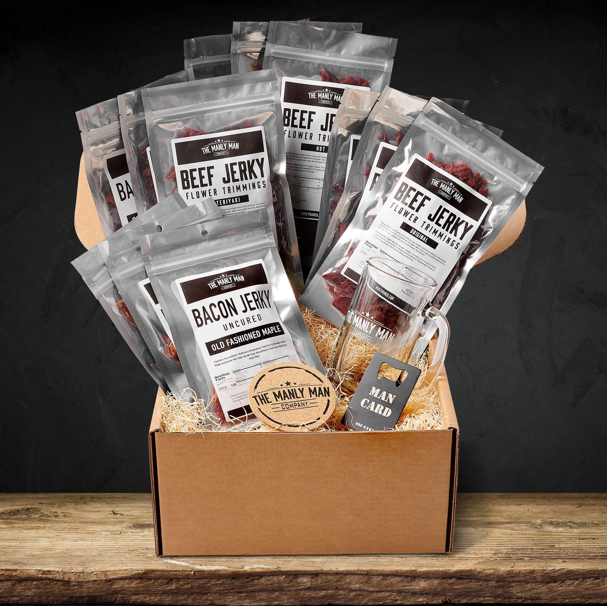 Curated beef jerky gift box on wood table, in front of black background