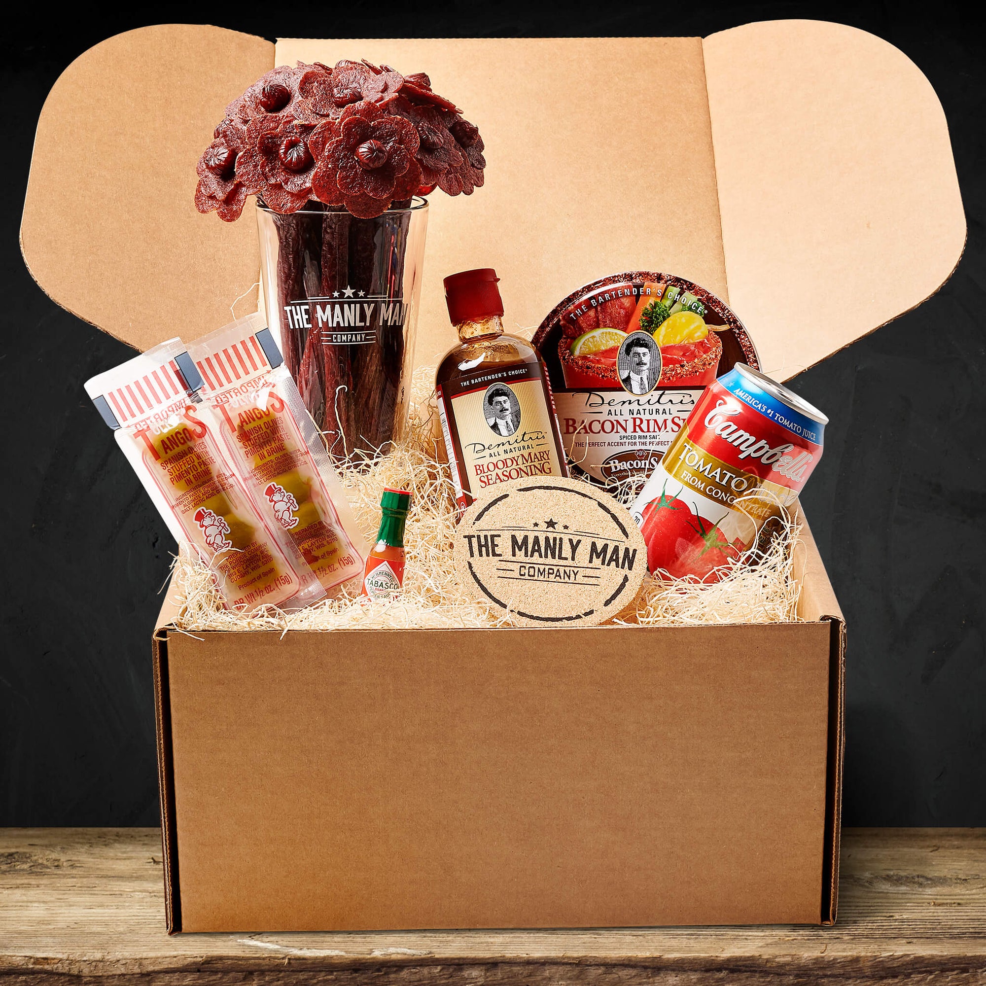 Bloody Mary kit on wood table and in front of black background, delivered as a gift for men