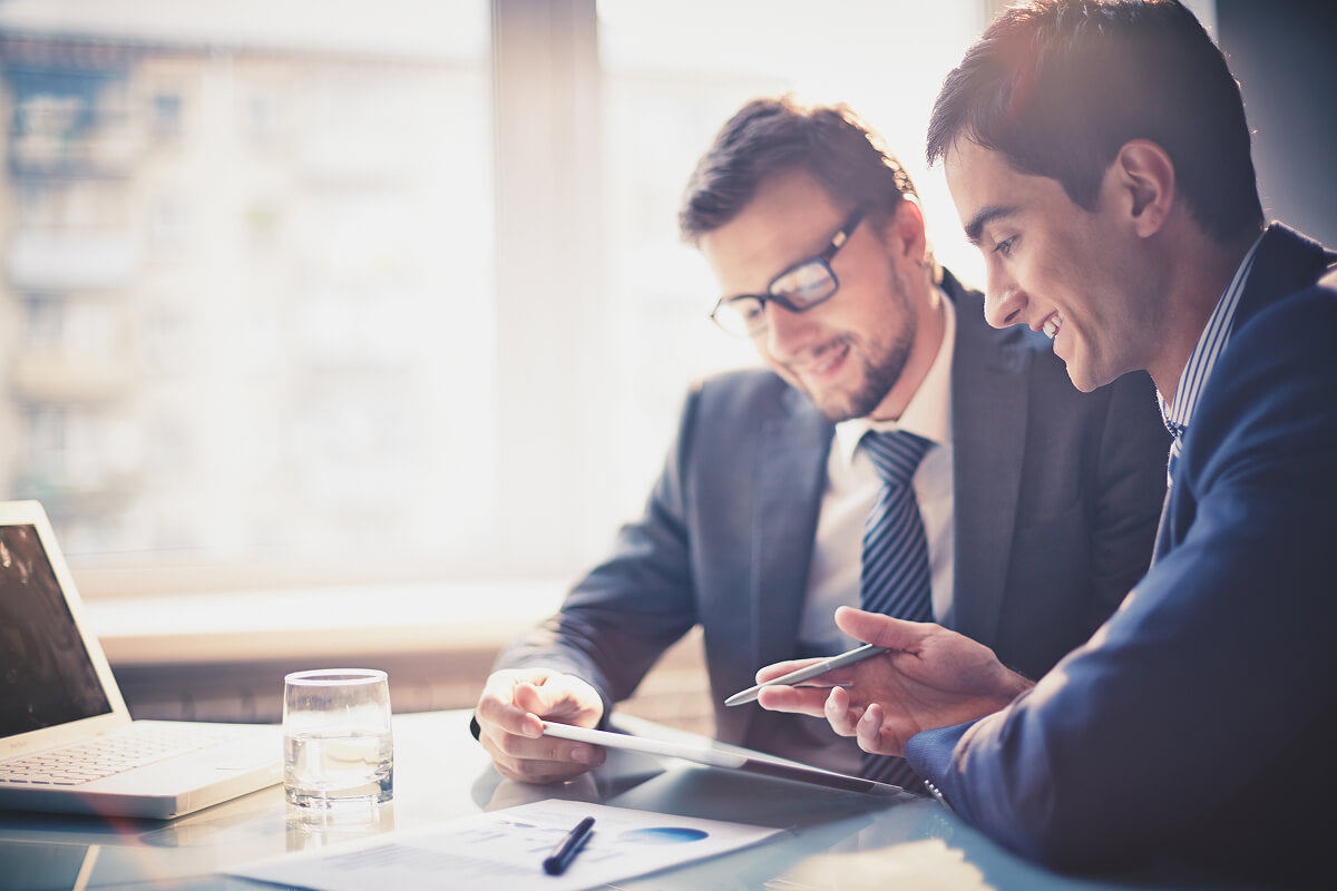 Team leader and colleague reviewing plans—because leadership deserves more than just a handshake.