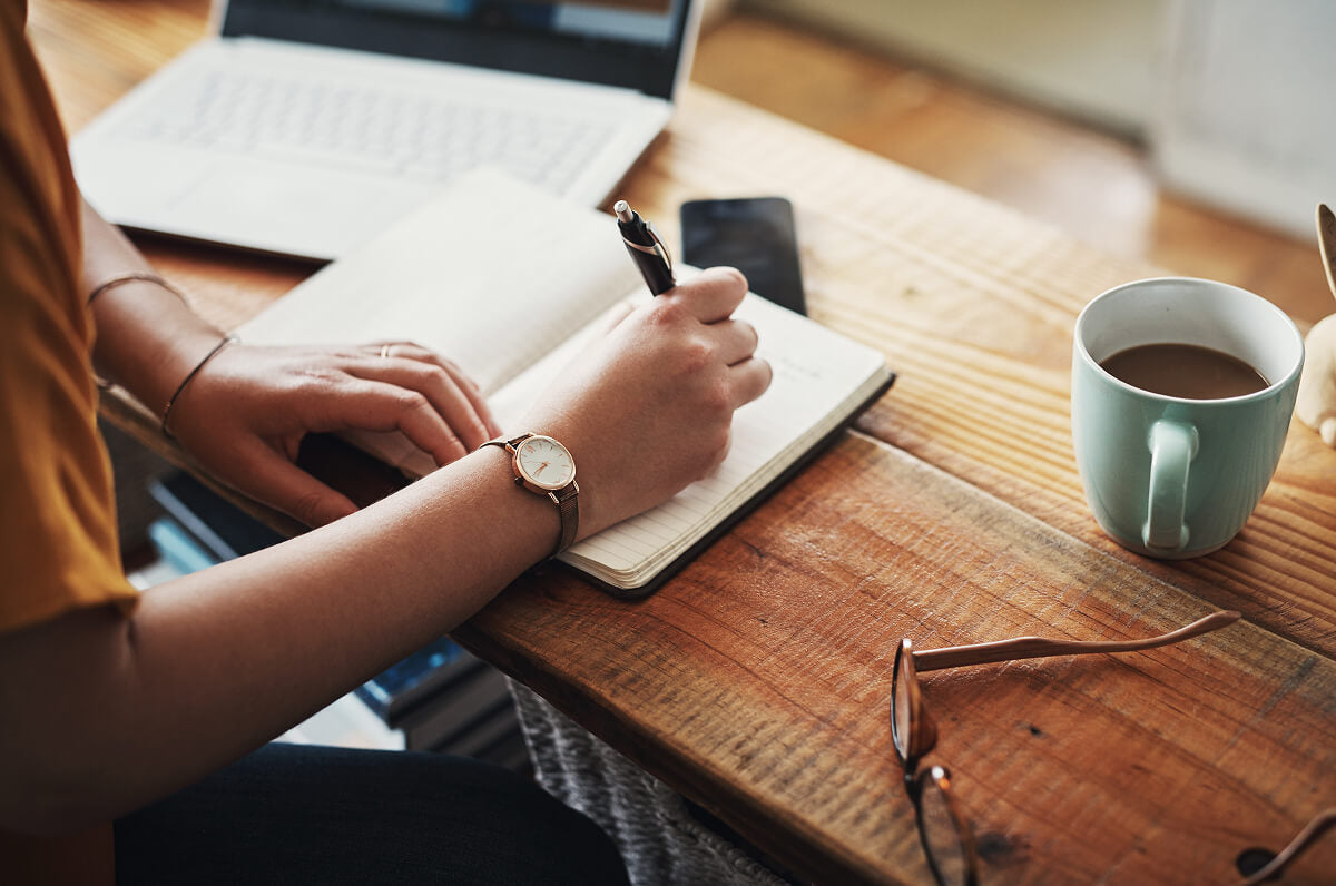 Employee at desk with coffee and planner—symbolizing thoughtful, flexible gift card options for hardworking teams.