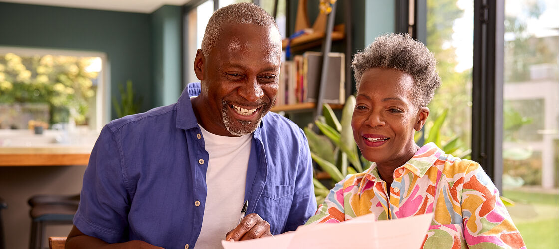 Older couple enjoying a surprise Christmas gift, representing thoughtful gifts for parents.