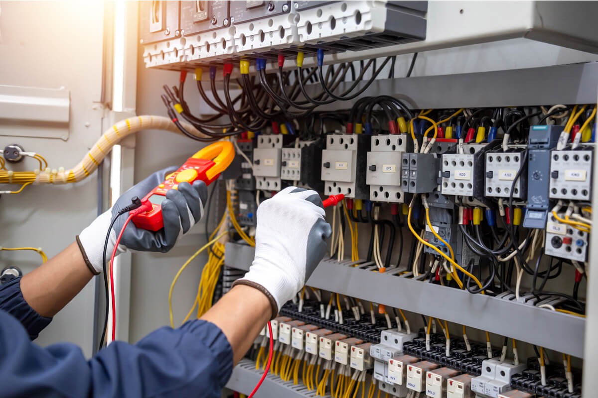 Gift ideas for electrical engineers – technician testing control panel wiring.