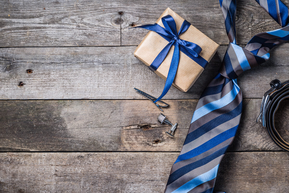 Bulk holiday gift ideas for employees featuring jerky samplers, bacon bouquets, and engraved ammo cans wrapped for Christmas.