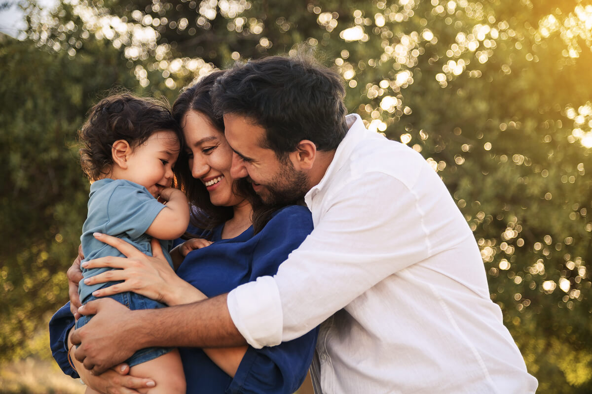 First-time dad holds his baby and partner close, soaking in the joy of his rookie dad year.