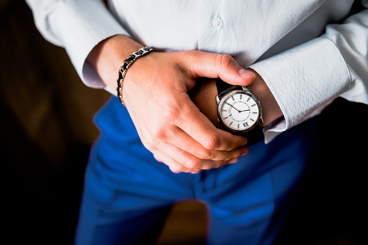 A suited best man clutching a sleek pocket watch—prepped, polished, and on time for the groom.