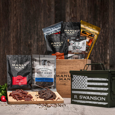 A curated beef jerky gift set by Manly Man Company featuring various jerky packs, a wooden gift box, and a personalized ammo can with an American flag design. Includes flavors like 'Hot Beef Jerky' and 'Cowboy Peppered".