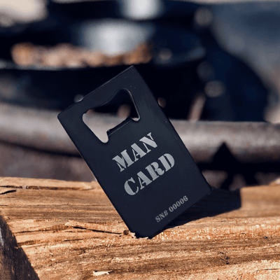 Alcohol bottle opener sitting on wood table, in front of barbecue grill