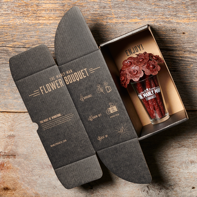 Beef jerky bouquet in open box on top of wood backdrop