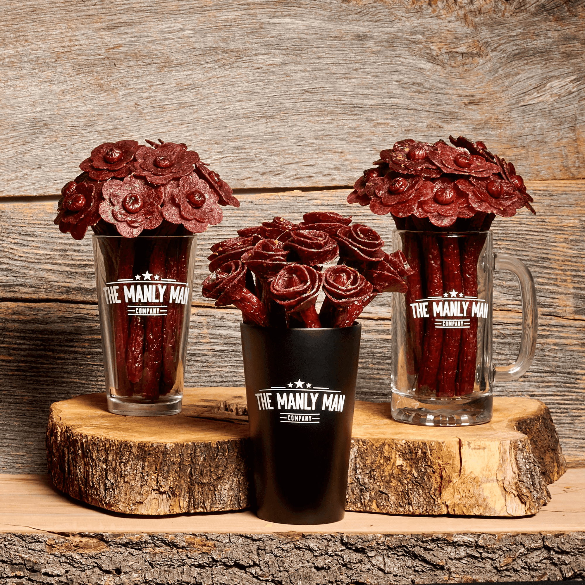 Three most popular man bouquets sitting on top of two logs